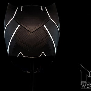 K&ouml;nnte beinhalten: Schwarz-wei&szlig;er Helm mit geometrischem Design. Der Helm ist aus hartem Material gefertigt und hat eine glatte Oberfl&auml;che.