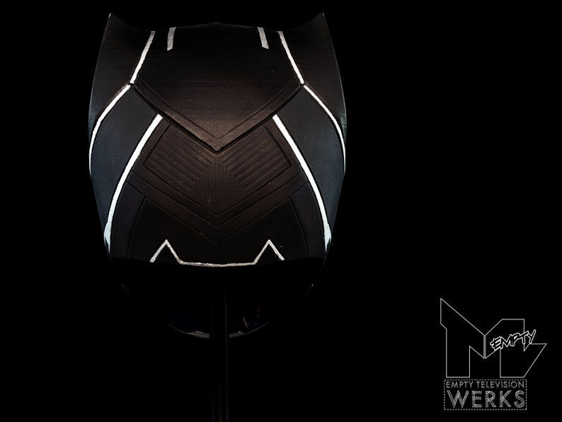 K&ouml;nnte beinhalten: Schwarz-wei&szlig;er Helm mit geometrischem Design. Der Helm ist aus hartem Material gefertigt und hat eine glatte Oberfl&auml;che.