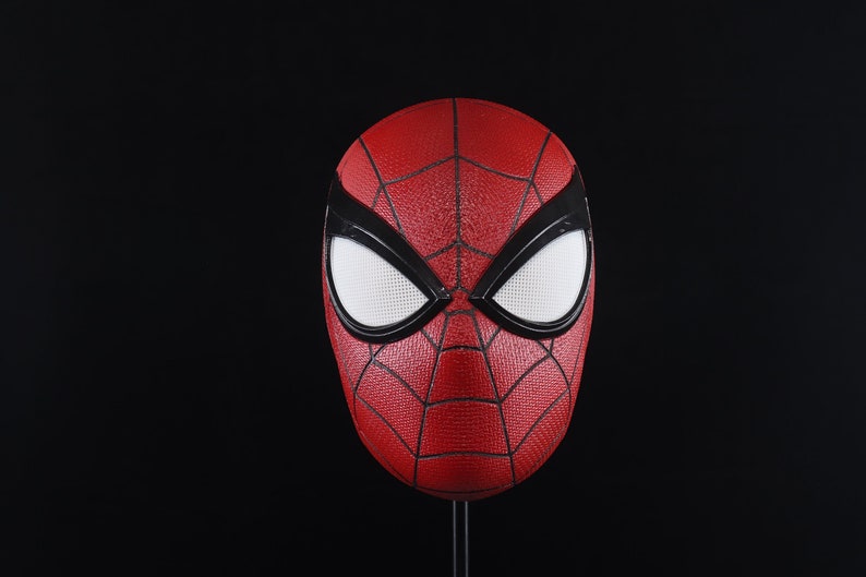 Puede incluir: Una m&aacute;scara de Spider-Man roja y negra con ojos blancos. La m&aacute;scara est&aacute; hecha de un material texturizado y tiene un dise&ntilde;o de telara&ntilde;a.