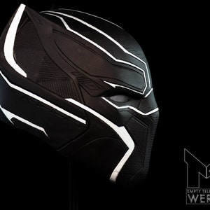 K&ouml;nnte beinhalten: Schwarze und wei&szlig;e Plastikmaske von Black Panther mit detailliertem Design. Die Maske ist zur Seite geneigt und zeigt die rechte Gesichtsh&auml;lfte.