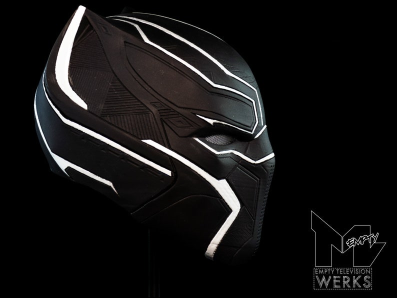 K&ouml;nnte beinhalten: Schwarze und wei&szlig;e Plastikmaske von Black Panther mit detailliertem Design. Die Maske ist zur Seite geneigt und zeigt die rechte Gesichtsh&auml;lfte.