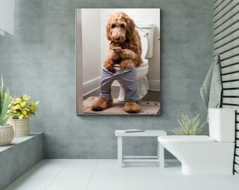 May include: A brown and white dog wearing blue jeans sits on a white toilet in a bathroom. The dog is looking down at a cell phone in its paws.