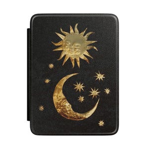 May include: A black rectangular e-reader case featuring a textured surface with a gold foil design of a sun with a face, a crescent moon with a face, and several small stars scattered across the front cover of the protective device case.