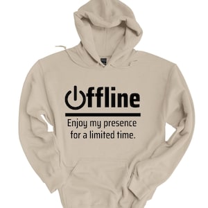 May include: A beige hoodie with a black graphic that says "offline" with a power button symbol and the text "Enjoy my presence for a limited time."