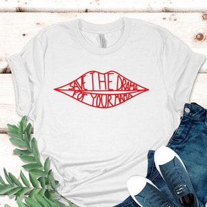May include: White t-shirt with a red outline of a pair of lips with the text "Save the drama for your mama" inside.