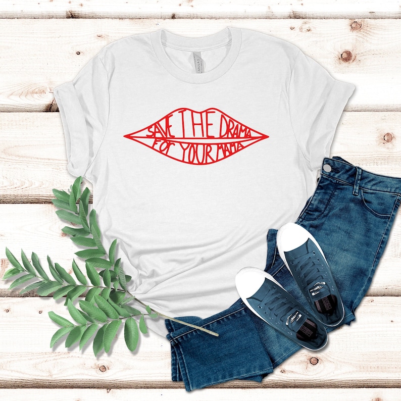 May include: White t-shirt with a red outline of a pair of lips with the text "Save the drama for your mama" inside.