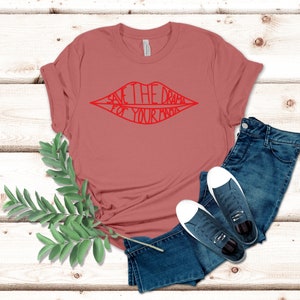 May include: A red t-shirt with the text "Save the drama for your mama" in a red lip shape.