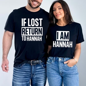 May include: Two black t-shirts with white text. The first shirt says "If Lost Return to Hannah". The second shirt says "I Am Hannah".
