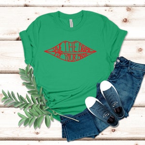 May include: Green t-shirt with a red graphic of a pair of lips with the text "Save the drama for your mama" inside.