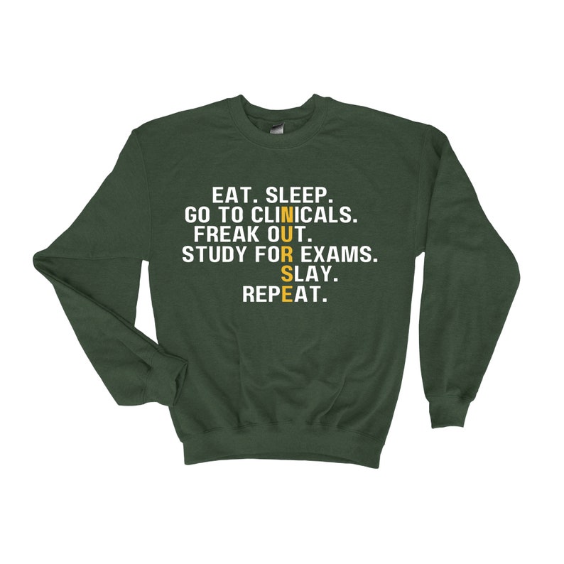 May include: Green sweatshirt with the text "EAT. SLEEP. GO TO CLINICALS. FREAK OUT. STUDY FOR EXAMS. SLAY. REPEAT." in white. The word "NURSE" is in yellow and vertical.