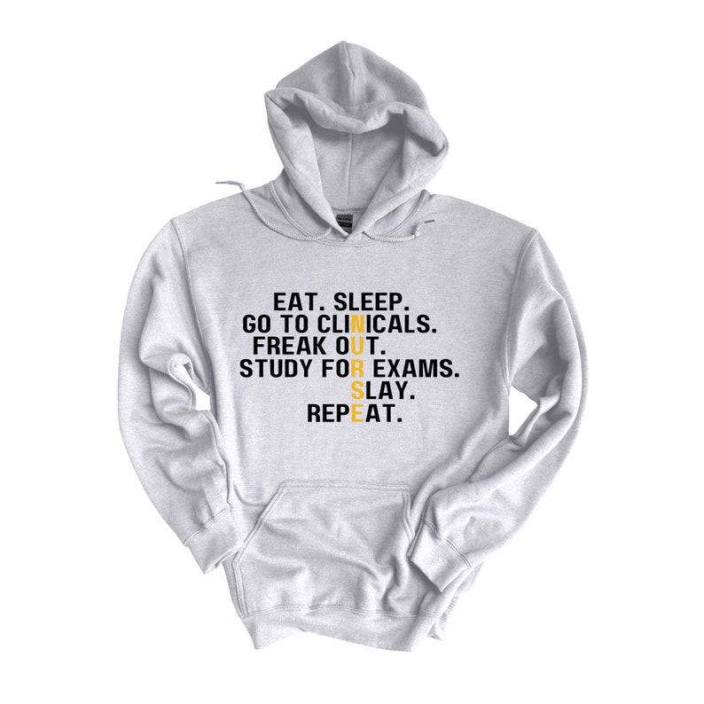 May include: A gray hoodie with the text "EAT. SLEEP. GO TO CLINICALS. FREAK OUT. STUDY FOR EXAMS. SLAY. REPEAT." in black with the word "NURSE" in yellow.