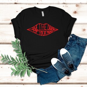 May include: Black t-shirt with a red graphic of a pair of lips with the text "Save the drama for your mama" inside.