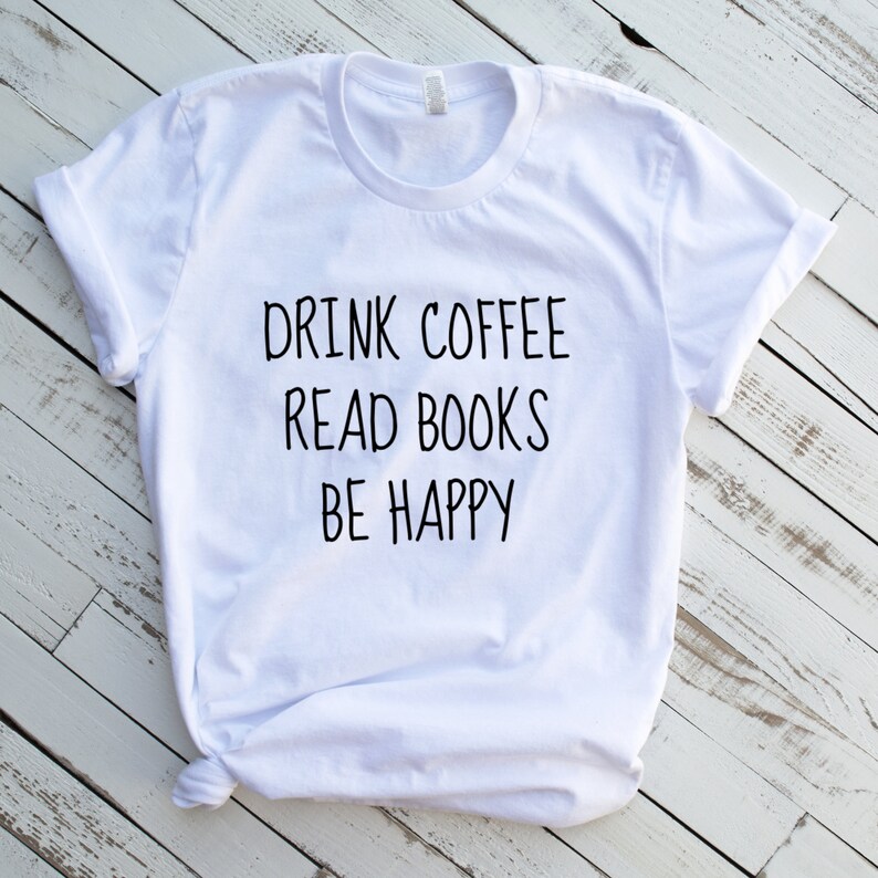 May include: White t-shirt with black text that reads "Drink Coffee Read Books Be Happy".