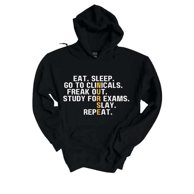 May include: Black hooded sweatshirt with white text that reads "EAT. SLEEP. GO TO CLINICALS. FREAK OUT. STUDY FOR EXAMS. SLAY. REPEAT." The word "NURSE" is spelled vertically in yellow.
