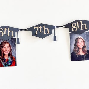 K&ouml;nnte beinhalten: Ein Abschlussbanner mit schwarzen Abschlusskappen und goldenen Zahlen. Das Banner enth&auml;lt Fotos einer Person in jeder Kappe. Die Zahlen auf den Kappen lauten "6. Klasse", "7. Klasse" und "8. Klasse".