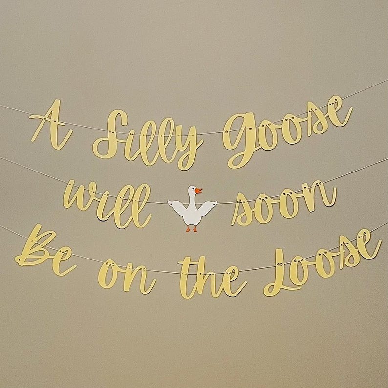 May include: A gold banner with the text "A Silly Goose Will Soon Be On The Loose" with a white paper goose cutout in the middle.