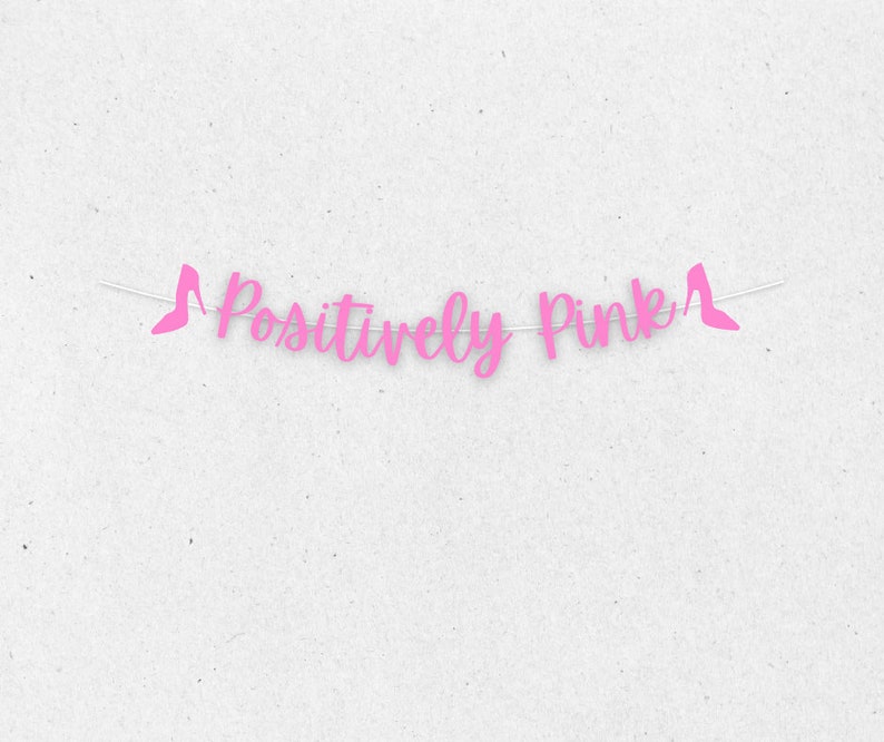 Puede incluir: Pancarta rosa con el texto "Positively Pink" y recortes de zapatos de tac&oacute;n alto rosas en cada extremo.