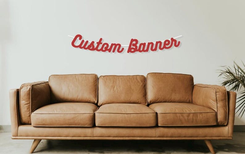 May include: Red custom banner with the text "Custom Banner" hanging above a brown leather sofa.