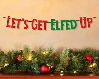 May include: A festive Christmas banner with the phrase "Let's Get Elfed Up" in red and green letters. The banner hangs above a garland of pine branches, red ornaments, and twinkling lights, creating a holiday atmosphere.