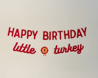 May include: Red banner with the words "Happy Birthday little turkey" and a small turkey illustration.