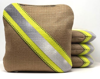May include: Four brown bean bags with yellow and silver reflective stripes. The bean bags are stacked on top of each other.