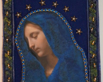 May include: A blue and gold framed image of a woman with her head bowed, wearing a blue veil. The image is surrounded by a border of gold stars and blue rhinestones.