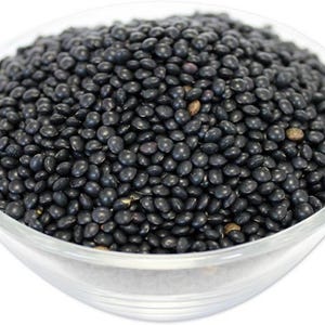 May include: A bowl filled with black lentils. The lentils are small and round, and they are a popular ingredient in many dishes.