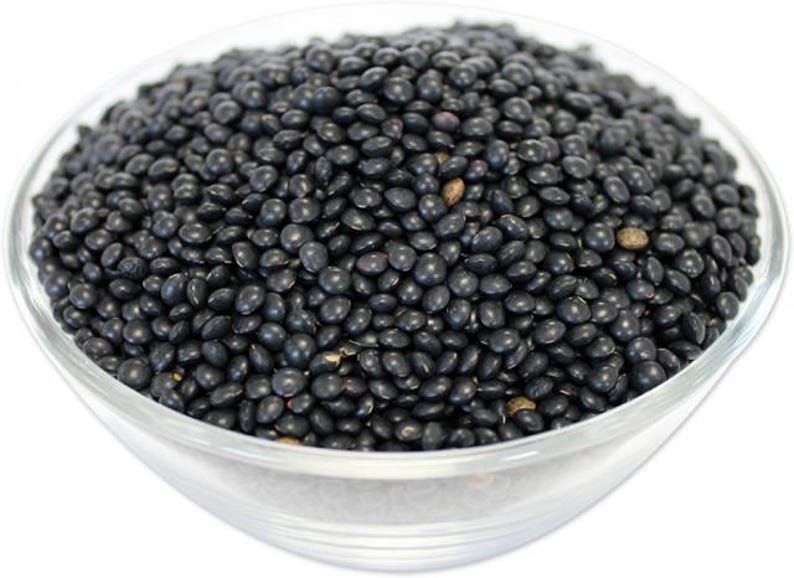 May include: A bowl filled with black lentils. The lentils are small and round, and they are a popular ingredient in many dishes.