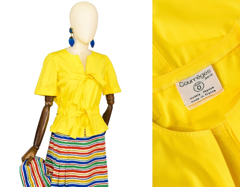 May include: A bright yellow short-sleeved jacket with a round neckline and two tie-front closures at the chest and waist. The interior label reads Courr&egrave;ges Paris, taille 0, modele depose, made in france. Paired with a multi-colored striped skirt.