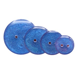 Könnte beinhalten: Ein Set aus vier kreisförmigen blauen Knöpfen, die in einer Reihe von groß nach klein angeordnet sind. Jeder Knopf hat eine glänzende, glitzernde Oberfläche mit zwei zentralen Löchern zur Befestigung. Die Knöpfe haben einen glatten Rand.