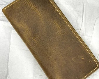 May include: A brown leather wallet with a stitched edge.