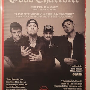May include: A promotional poster for the band Good Charlotte. The poster features a group photo of the band members and text that reads "MOTEL DU CAP BEST ROCK ALBUM". Additional text includes "I DON'T WORK HERE ANYMORE" and quotes from critics.