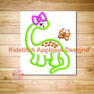 May include: Green dinosaur applique with a pink bow and orange butterfly. Kidstitch Applique Designs.