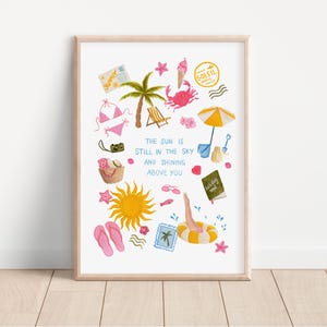 Op de afbeelding: Een witte kunstprint met kleurrijke zomerse illustraties zoals een palmboom, krab, ijsje, zon, slippers en strandspullen. De tekst luidt: THE SUN IS STILL IN THE SKY AND SHINING ABOVE YOU. Het ontwerp bevat postzegels en diverse kleine iconen.