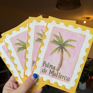 May include: A set of five postcards with a yellow border and a pink background. Each postcard features a watercolour illustration of a palm tree and the text "Palma de Mallorca".