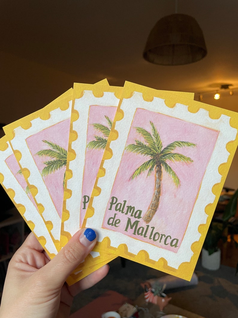 May include: A set of five postcards with a yellow border and a pink background. Each postcard features a watercolour illustration of a palm tree and the text "Palma de Mallorca".