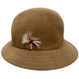 Pode incluir: Um chap&eacute;u cloche castanho com uma copa arredondada e uma aba pequena. O chap&eacute;u &eacute; adornado com um detalhe decorativo de penas em tons de branco, castanho e amarelo. Este chap&eacute;u de estilo vintage &eacute; um acess&oacute;rio cl&aacute;ssico.