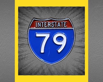 May include: A blue and red enamel pin featuring a highway sign with the text "Interstate 79" in white.