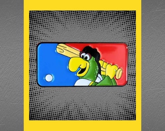 May include: A green parrot wearing a baseball cap and holding a bat, with a red, white, and blue baseball diamond background. The parrot is smiling and has a white baseball in its mouth.