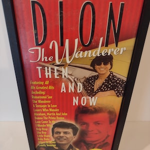 Puede incluir: Un conjunto de CD enmarcado titulado "DION The Wanderer THEN AND NOW" con un fondo rojo y amarillo. La portada presenta imágenes de Dion y enumera sus mayores éxitos, incluyendo "Runaround Sue".
