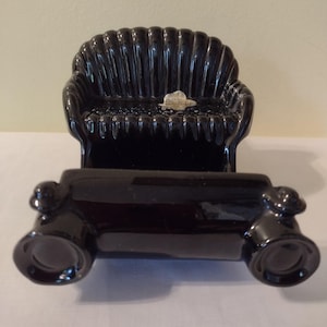 May include: Black ceramic figurine of a couch and a coffee table. The couch has a scalloped back and the coffee table has rounded edges. The figurine is made in Czechoslovakia.