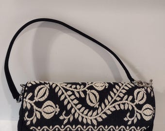 Bolso pequeño Vera Bradley acolchado con bordado y cierre de solapa. Medidas: 15 cm de alto x 25 cm de ancho. Color: negro y blanco. Hecho en China.