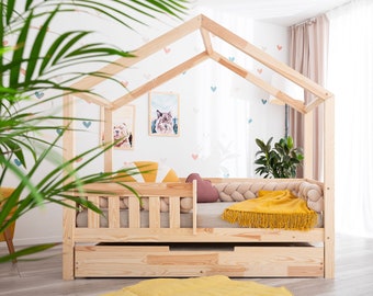 Cama infantil Montessori con forma de casita, barandilla de seguridad y cajón, de madera natural.