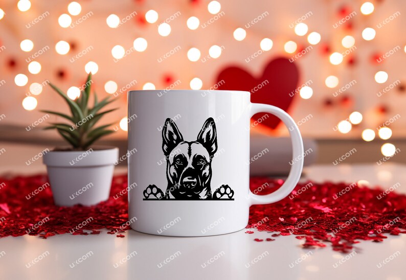 May include: White ceramic mug featuring a black silhouette of a dog's face and paws. The dog's head is centered on the mug, with its ears perked up. The mug has a curved handle and is set against a blurred background.