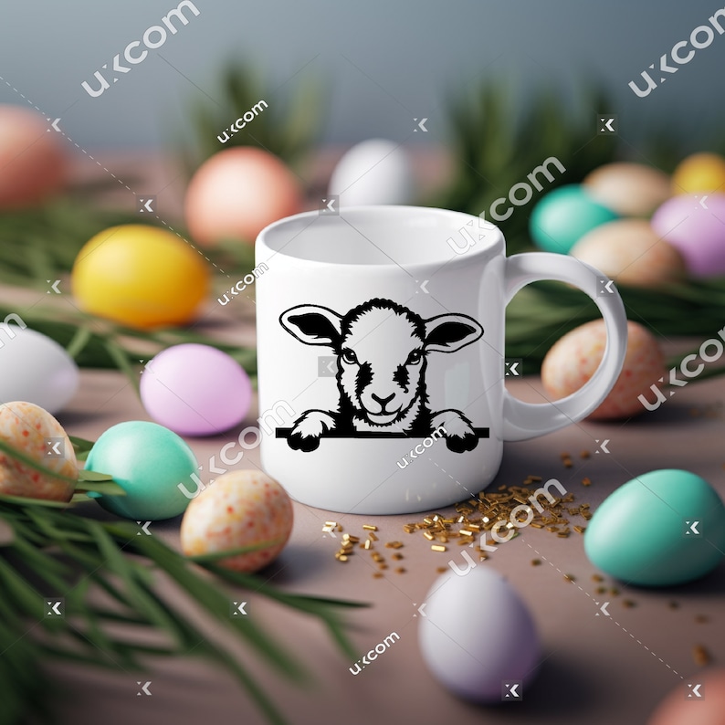 Puede incluir: Taza de cer&aacute;mica blanca con una ilustraci&oacute;n en blanco y negro de un cordero asom&aacute;ndose por la parte superior. La taza est&aacute; rodeada de huevos de Pascua de colores pastel y hierba verde.