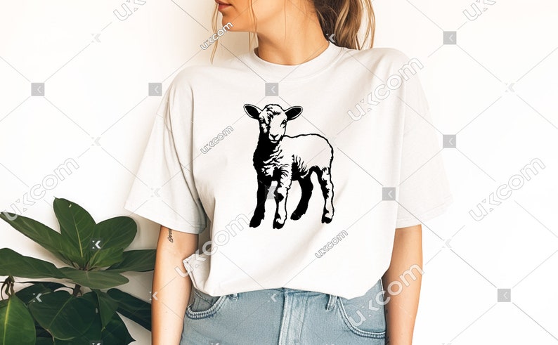 Puede incluir: Una camiseta blanca con una silueta negra de un cordero en la parte delantera.