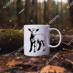 Puede incluir: Taza de cer&aacute;mica blanca con una silueta negra de un cordero. La taza est&aacute; sobre un lecho de hojas y ramitas marrones.