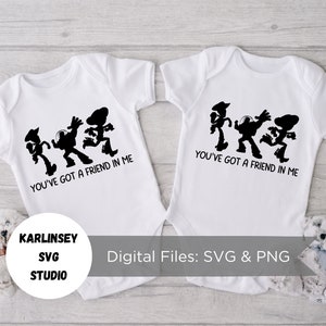 Op de afbeelding: Twee witte baby-rompers met zwarte silhouetten van Woody, Buzz Lightyear en de alien uit Toy Story. De rompers hebben de tekst "You've got a friend in me" erop gedrukt.