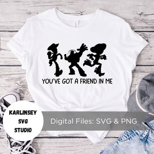 Op de afbeelding: Wit T-shirt met een zwart silhouet van Woody, Buzz Lightyear en Jessie uit Toy Story. De tekst "You've got a friend in me" staat onder de silhouetten.
