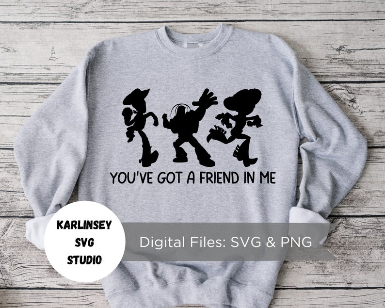 Op de afbeelding: Grijs sweatshirt met een zwart silhouet van Woody, Buzz Lightyear en Jessie uit Toy Story. De tekst "You've got a friend in me" is onder de personages gedrukt.
